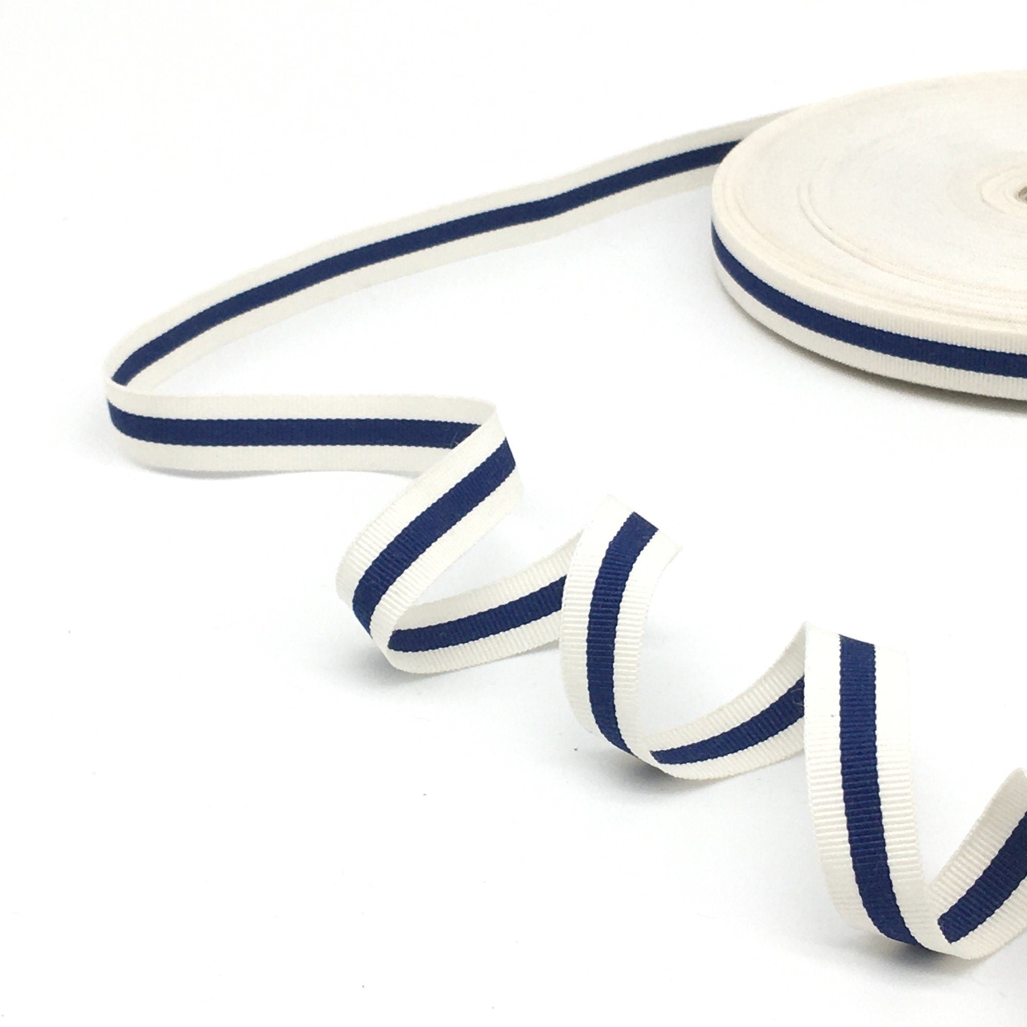 A white ribbon with a navy blue stripe running down the center.