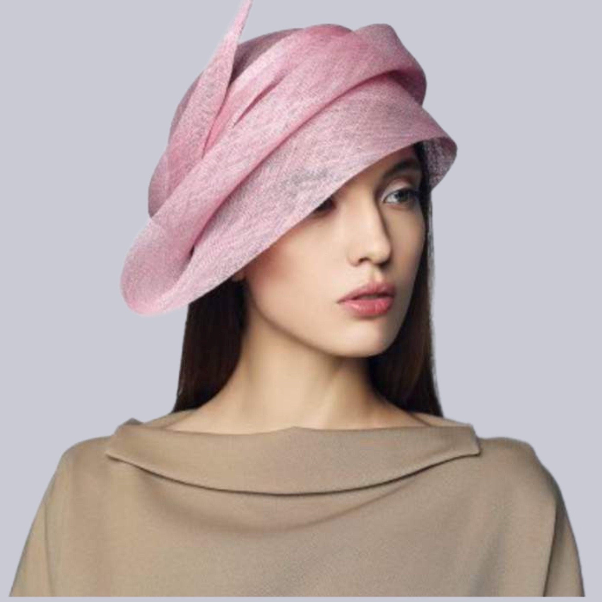 Elegant woman wearing pink sinamay straw couture hat.