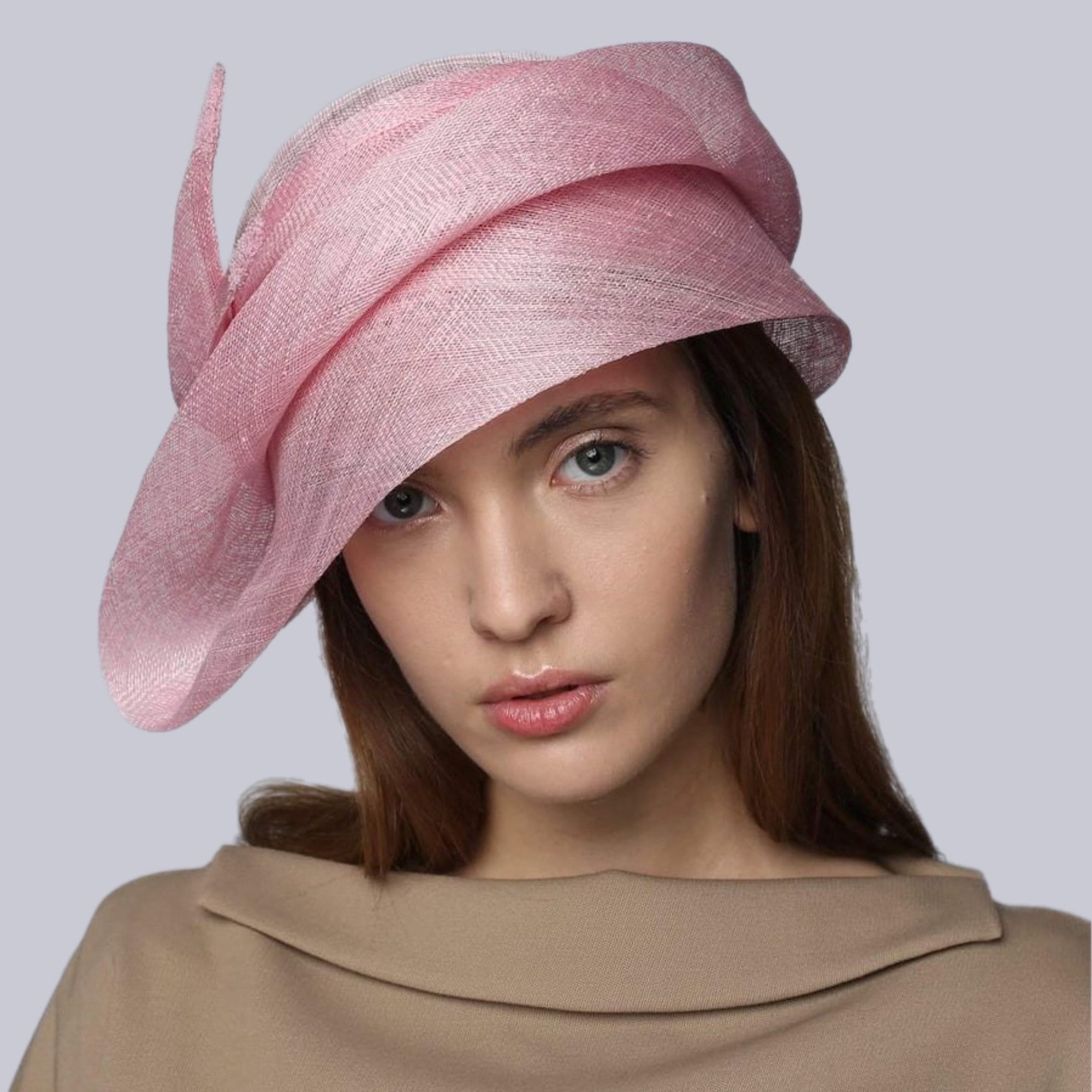 A pink cloche hat with a soft flowing design. The hat is made of a lightweight material and has a delicate, feminine look.