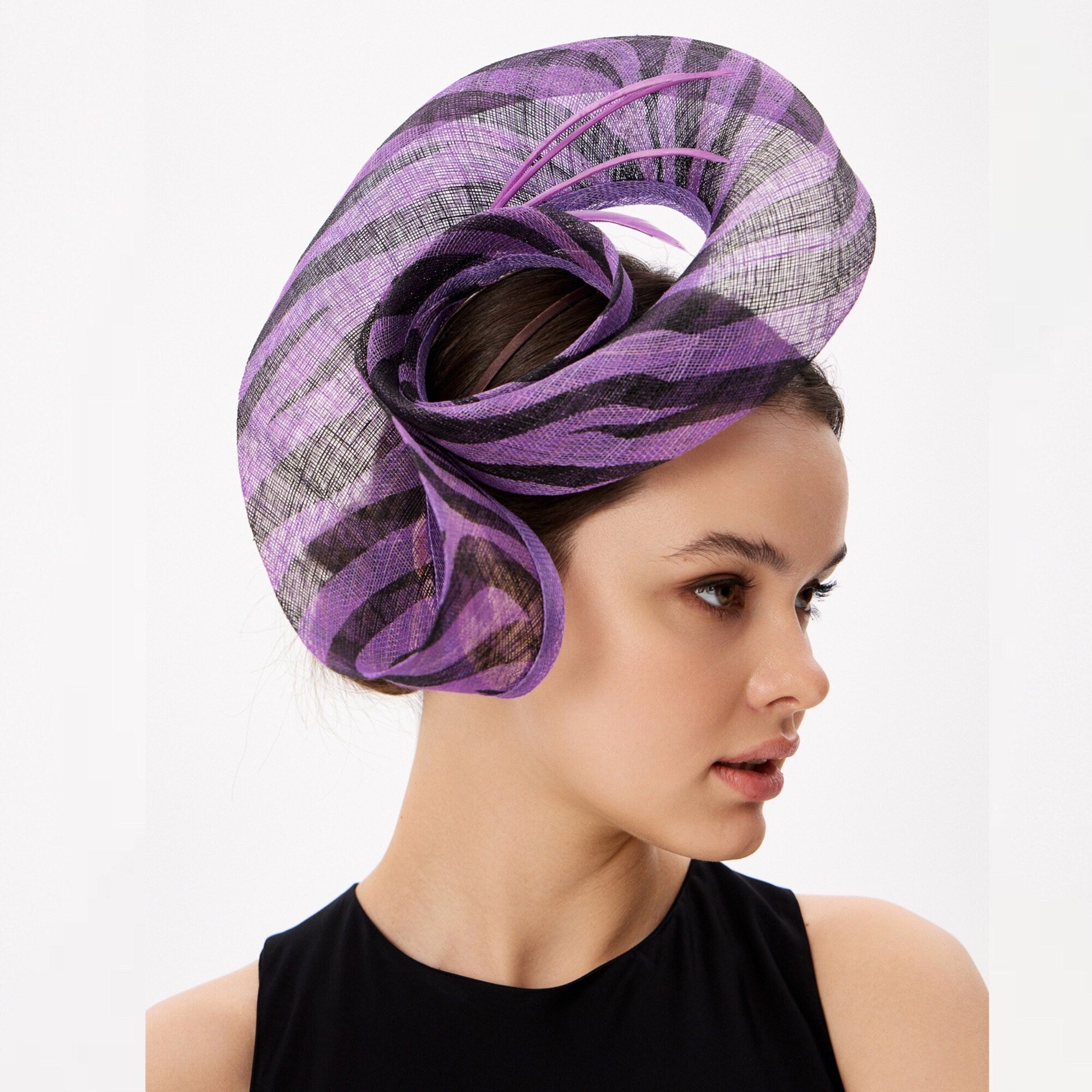 Purple and black striped headpiece, likely a fascinator or hat, with a swirling design. The headpiece features a combination of purple and black stripes, with delicate purple accents. The design is elegant and suitable for formal events.