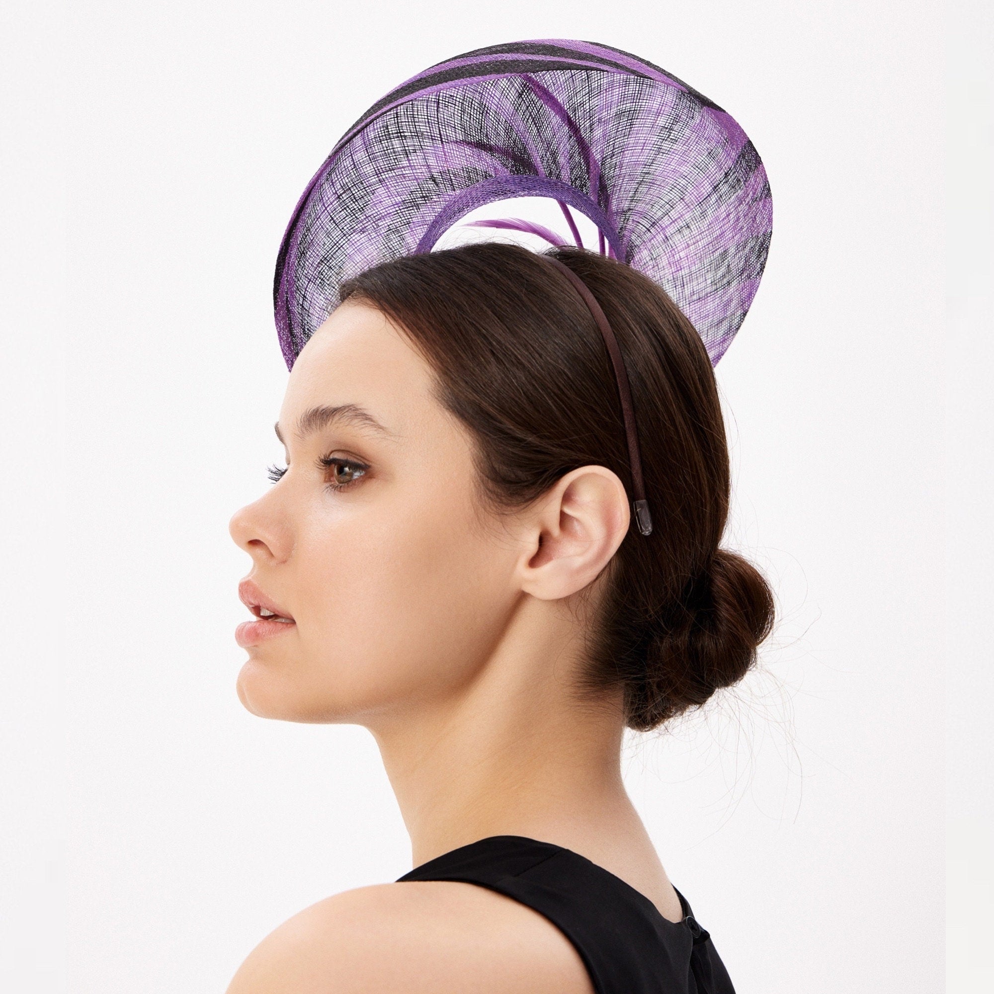 Purple and black fascinator hat with a circular design.