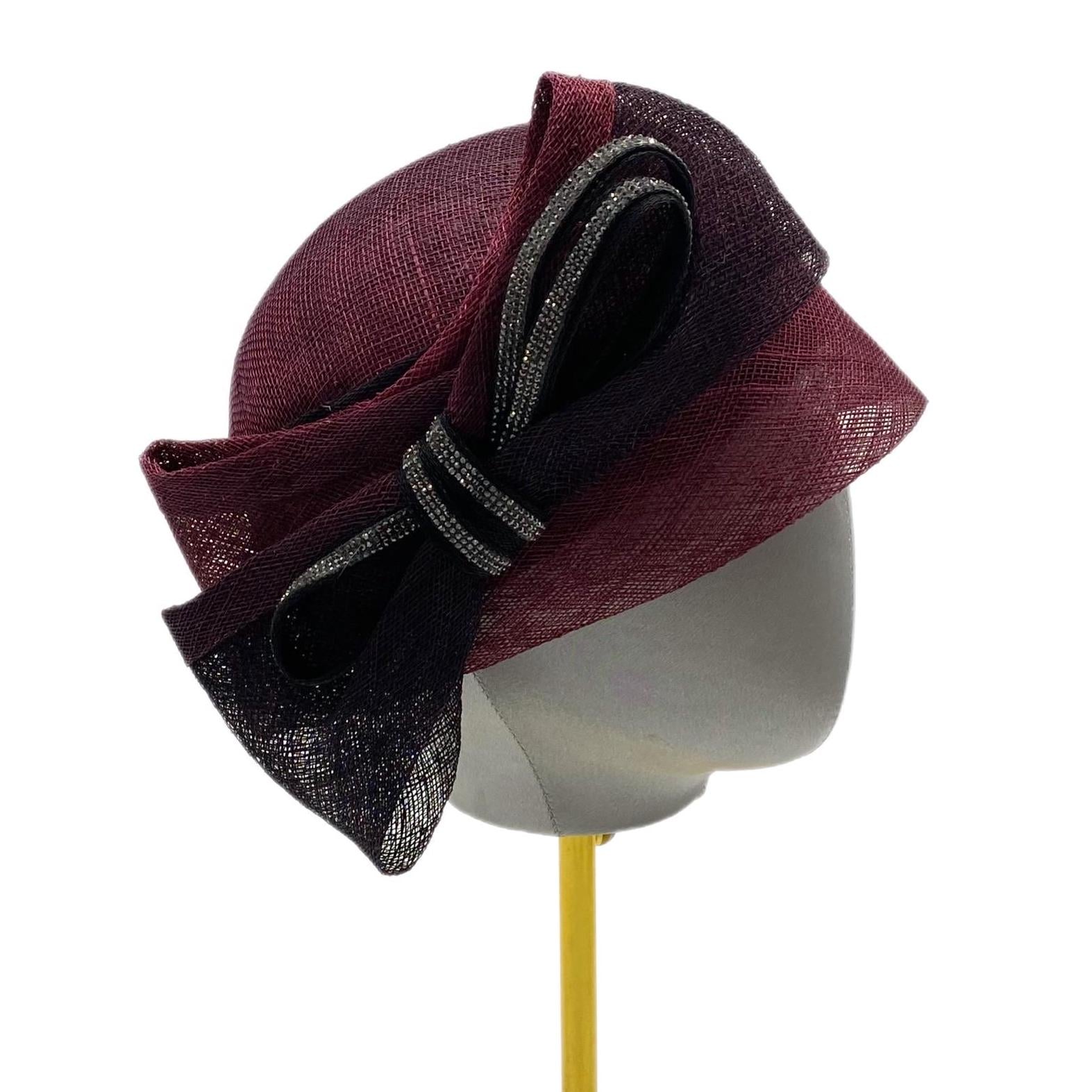 Burgundy and black hat with a large bow adorned with rhinestones.