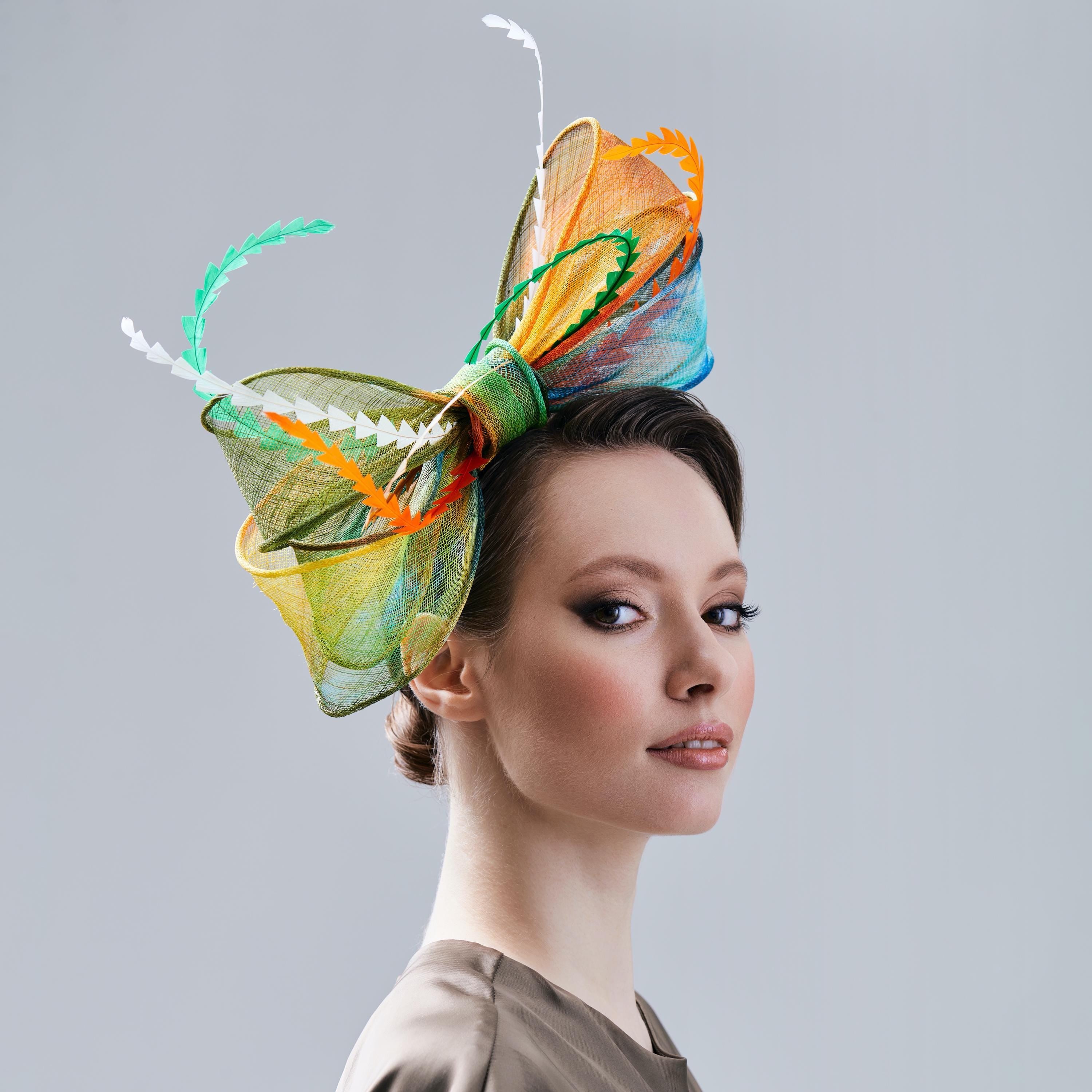 A colorful, multi-layered bow hat with green, orange, yellow, and blue accents.