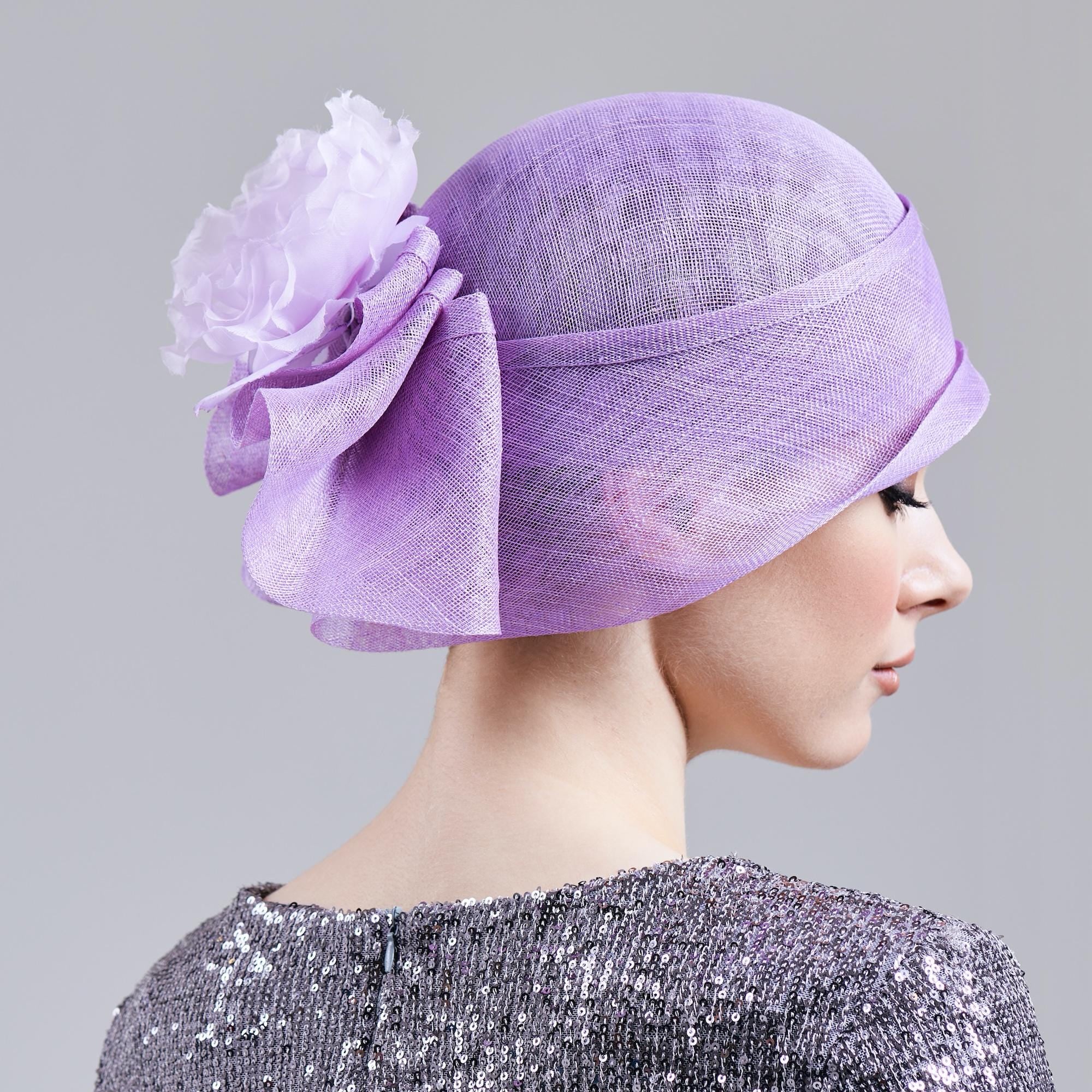 Lavender-colored cloche hat with a large flower accent.