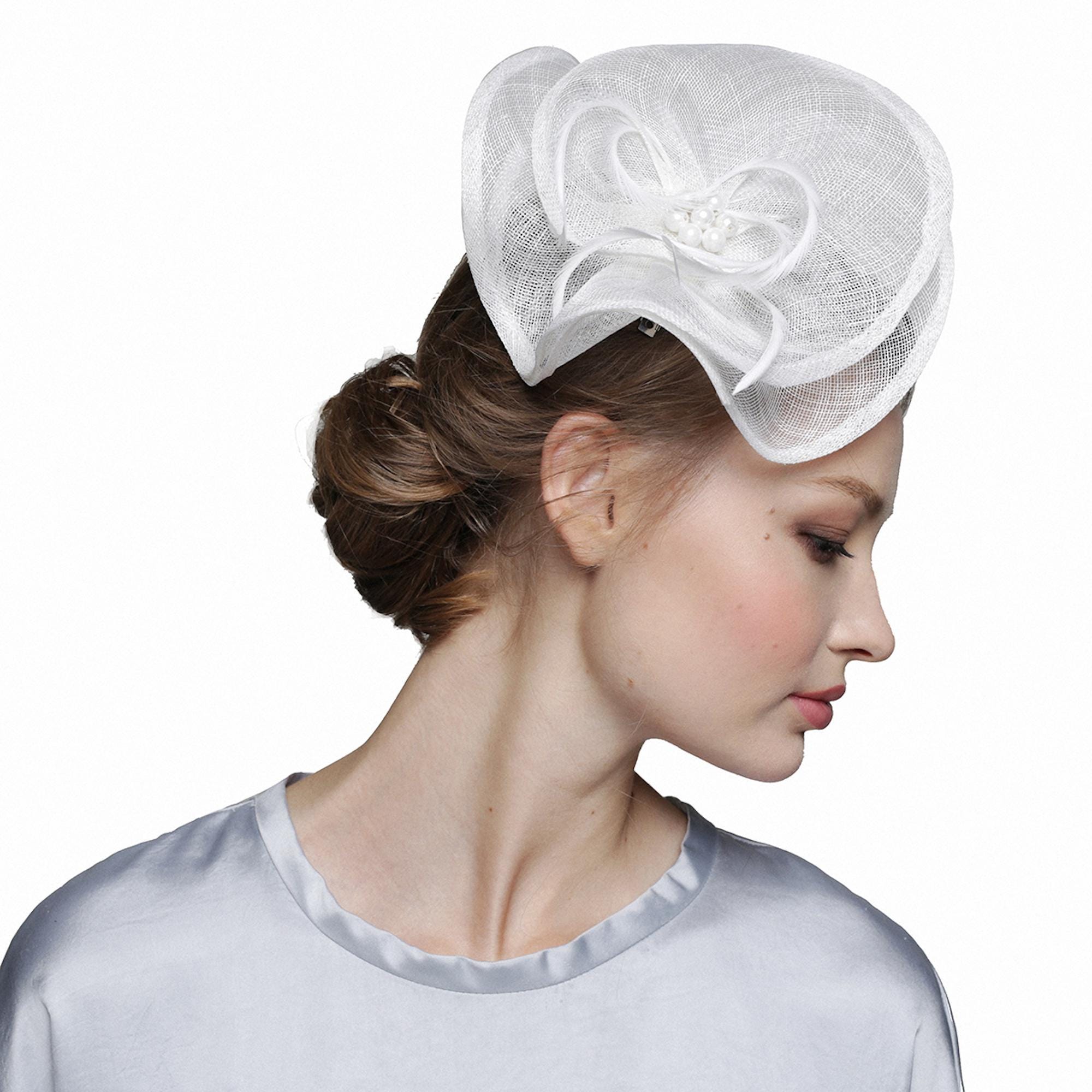 White headpiece with a floral design. The headpiece features a layered, open weave fabric with gold accents and a cluster of pearls at the center.